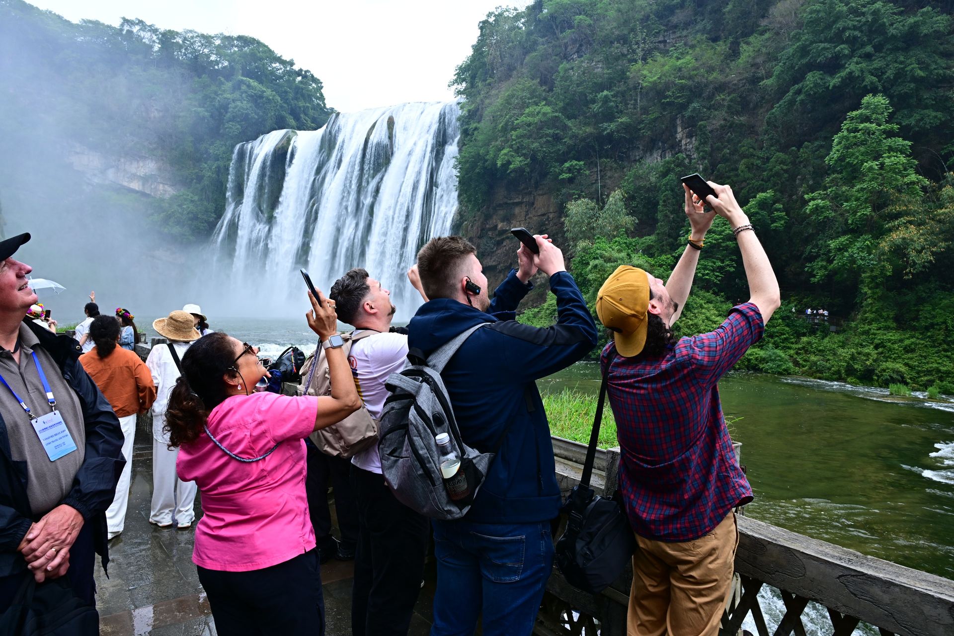 European travel trade visitors photographing Huangguoshu Waterfall in Guizhou